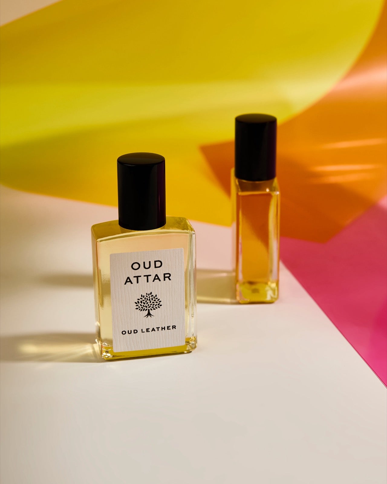 Two Oud Attar bottles against bright summer colours