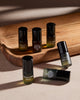 Six 2ml Discovery Collection bottles on a wooden tray in sunlight