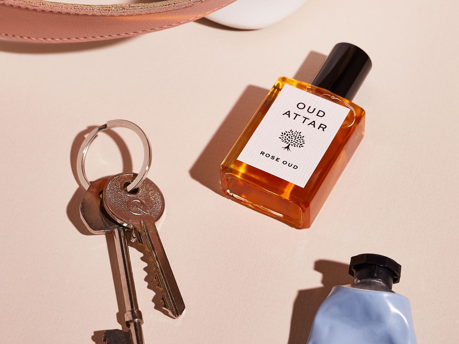 Rose Oud perfume oil beside a set of old keys