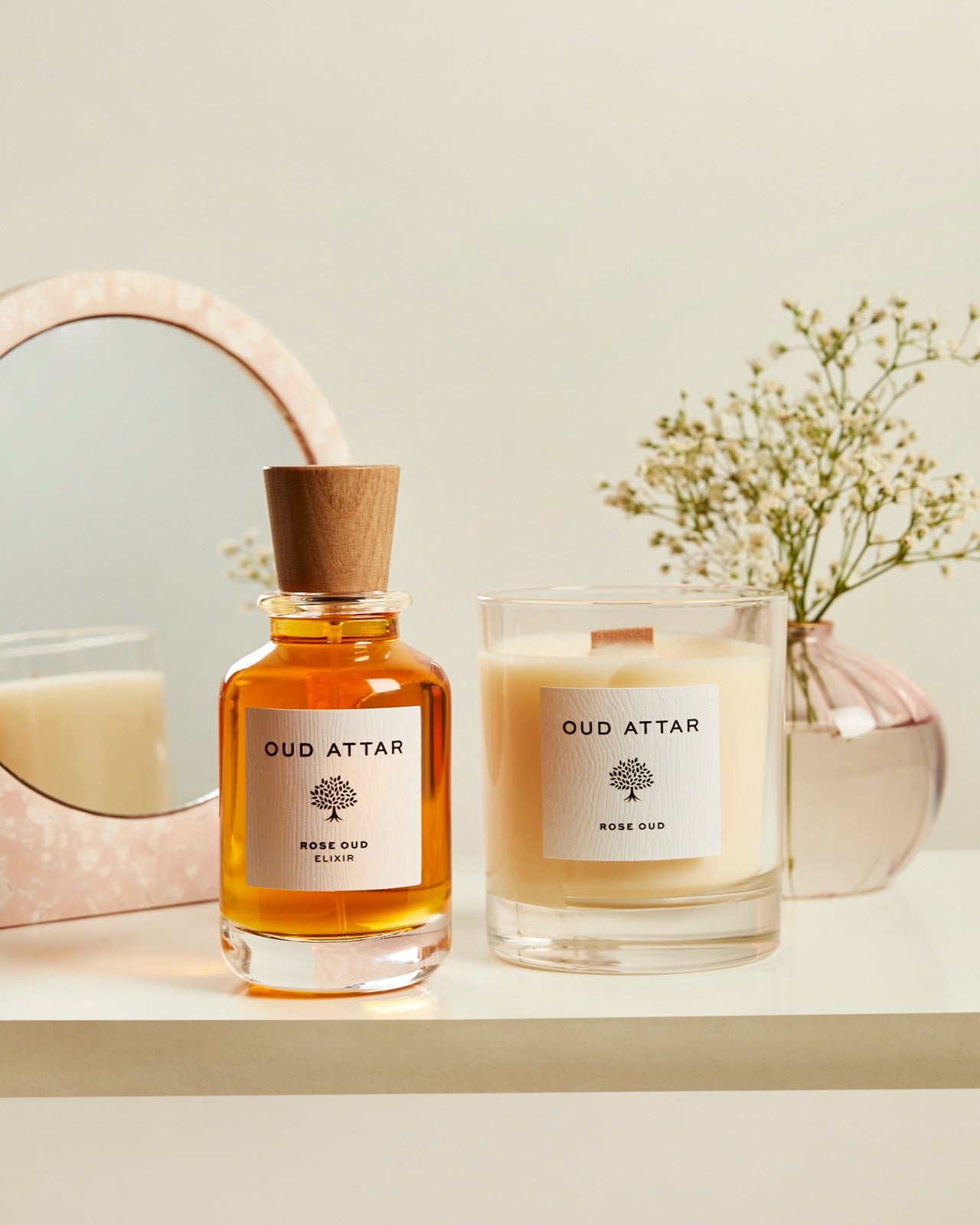 Rose Oud elixir and candle on a dressing table