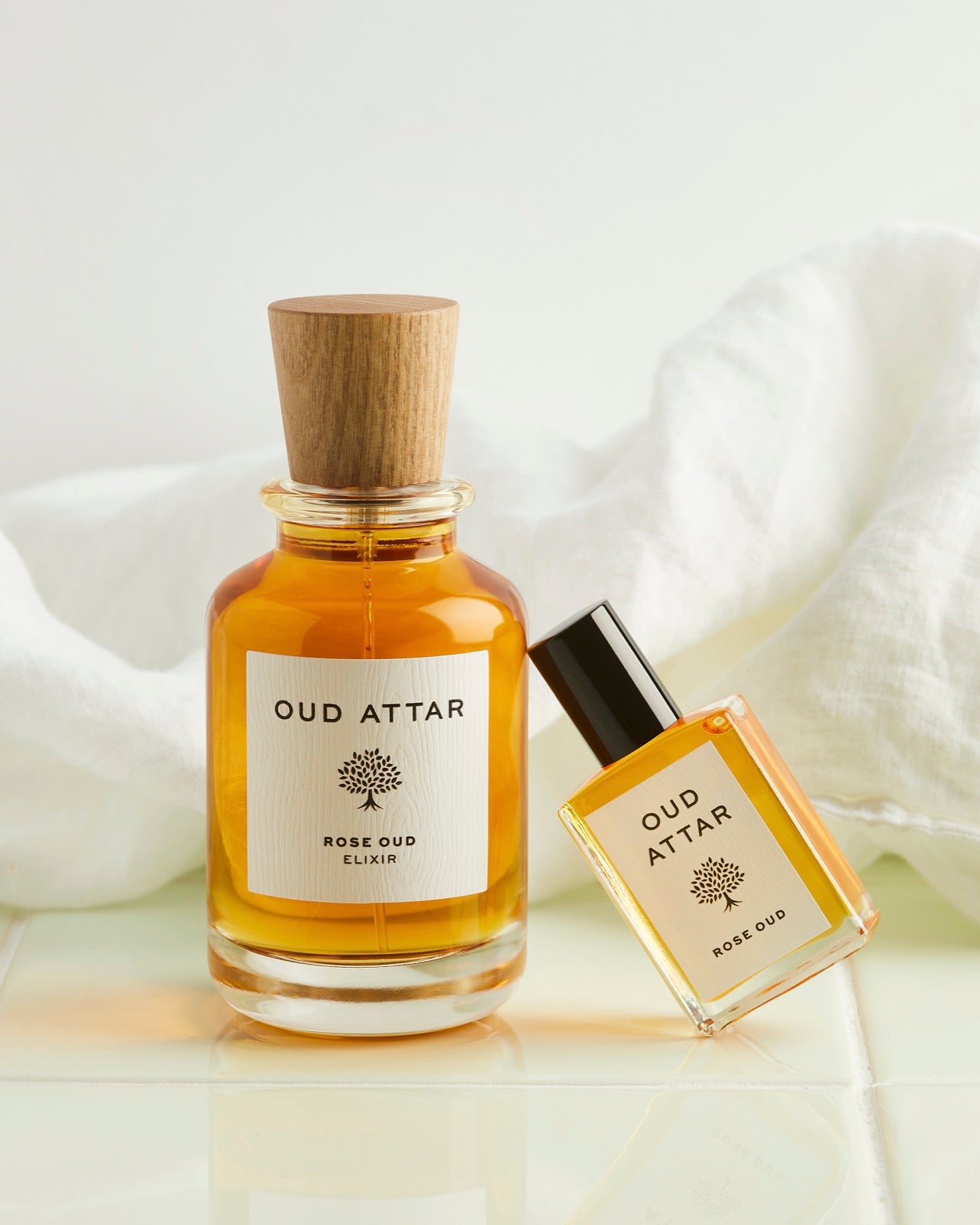 Amber oud oil bottles against crisp white linen